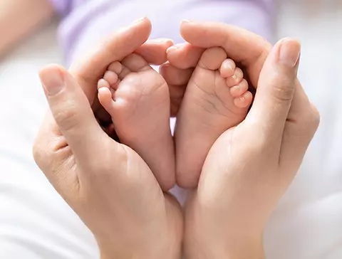 Pés bebês e mãos de adulto